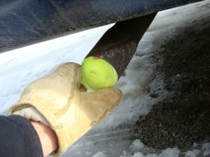 Ordinary tennis ball being used to try and detect an exhaust leak.